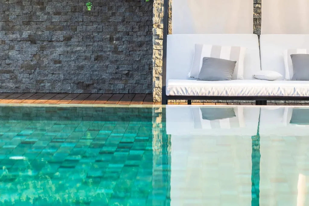 piscina exterior con sillones sombrillas